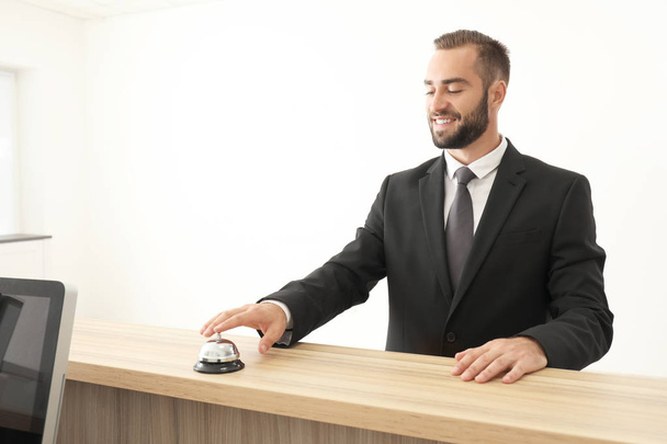 Man ringing in service bell on reception desk - Fotó, kép