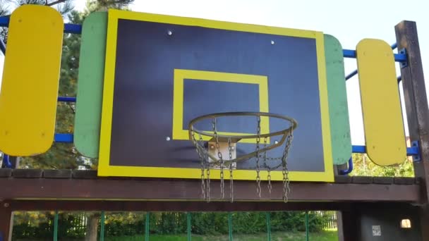 Мяч проходит через корзинку обруча на школьной баскетбольной площадке. Баскетбол проваливается в сетку
. - Кадры, видео