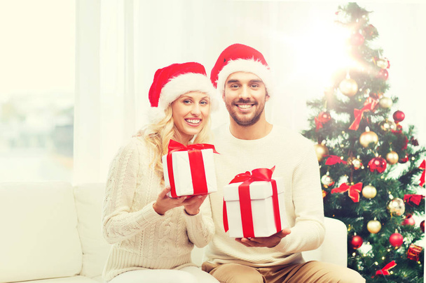 szczęśliwa para w domu z Boże Narodzenie pudełeczka - Zdjęcie, obraz
