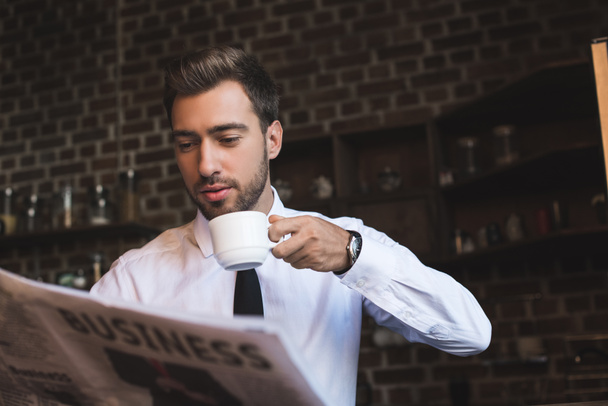 Empresario bebiendo café y leyendo periódico
 - Foto, Imagen