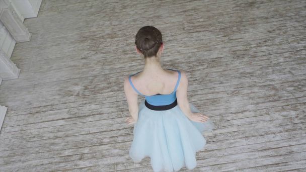 Gyönyörű lány táncos végez klasszikus balett elemei a Loft design. Női balerina táncos. Szoros fel, A balett táncosok lábak mint ő gyakorlatok pont gyakorlatok, lassú mozgás - Fotó, kép
