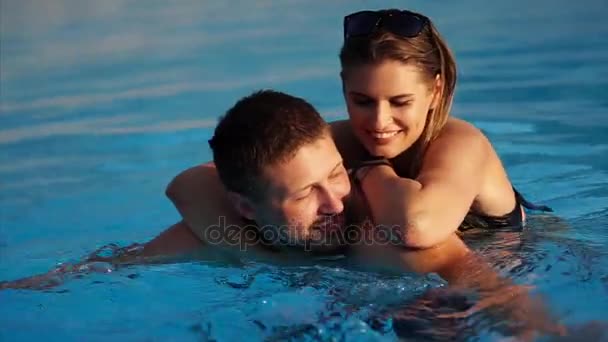Молодая любящая пара проводит день в бассейне вместе летом
. - Кадры, видео