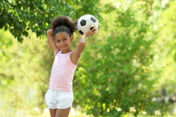 Cute African American girl with ball in park - 写真・画像