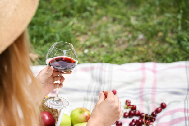 Woman holding glass of wine on picnic   - Photo, image