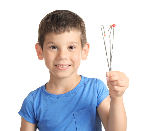 Cute boy with logopedic probes for speech correction on white background - Photo, image