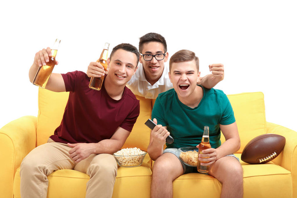 Young men watching TV on sofa - Foto, afbeelding