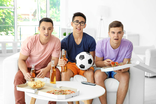 Young men watching TV at home - Valokuva, kuva