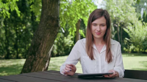 Fiatal hölgy használata egy ipad a parkban - Felvétel, videó