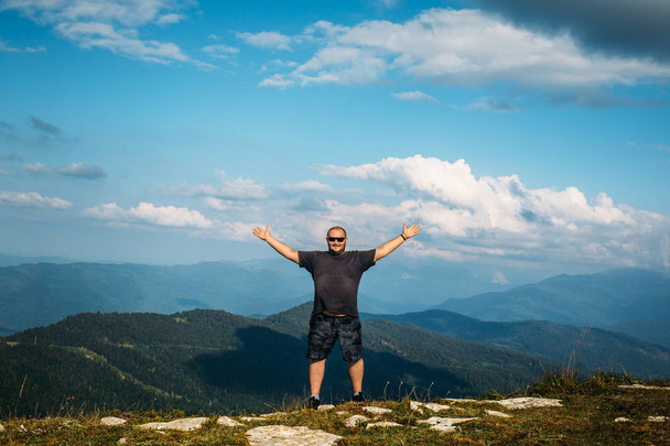 Feliz gesto del hombre de triunfo con los brazos en el aire en el fondo del paisaje valle de montaña
 - Foto, imagen
