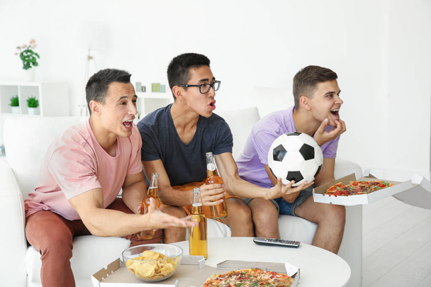 Young men watching TV at home - Foto, imagen