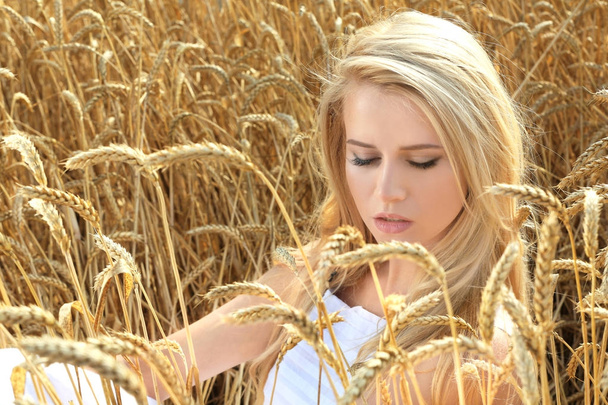 Young woman in wheat field - Фото, изображение