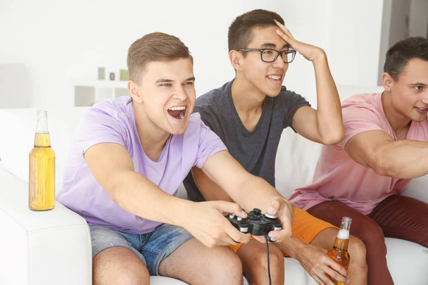 Young men playing video games on TV at home - Photo, Image