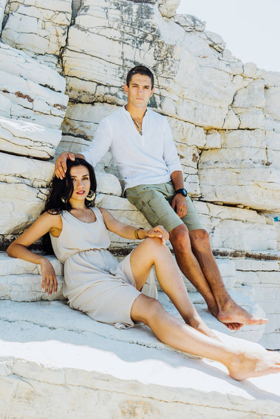 Young stylish couple in love posing against white rocks, romance in summer - 写真・画像