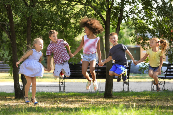 Group of children jumping in park - Foto, afbeelding