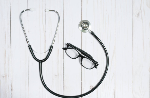 Medical stethoscope and glasses on white desk. - Foto, Imagem