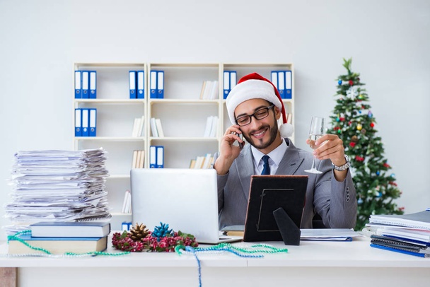 Młody biznesmen świętuje Boże Narodzenie w biurze - Zdjęcie, obraz
