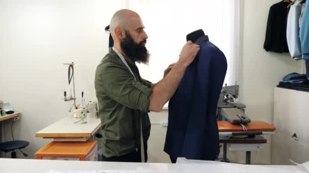 The tailor works with the lapel of the jacket on the dummy - Záběry, video