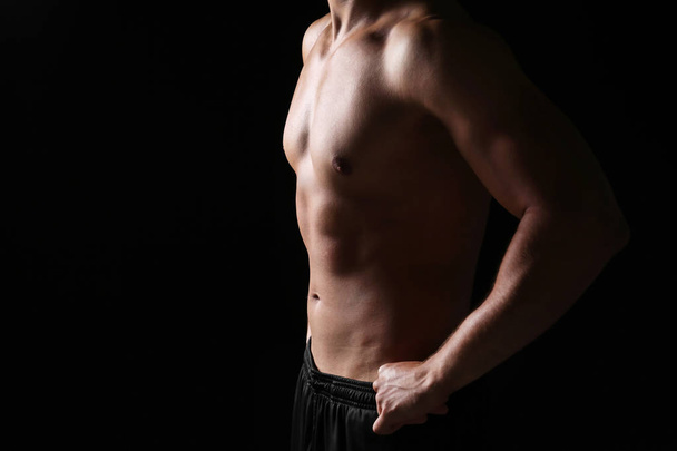 Sporty young man on dark background - Valokuva, kuva