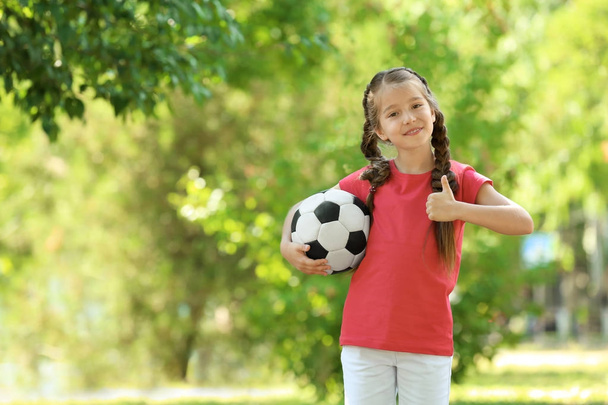 Cute girl with soccer ball in park - 写真・画像
