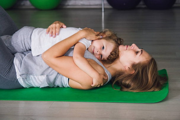 Mother and baby girl do exercises together in the gym - Fotografie, Obrázek
