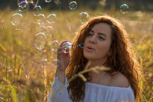 Красивая девушка делает мыльные пузыри
 - Фото, изображение