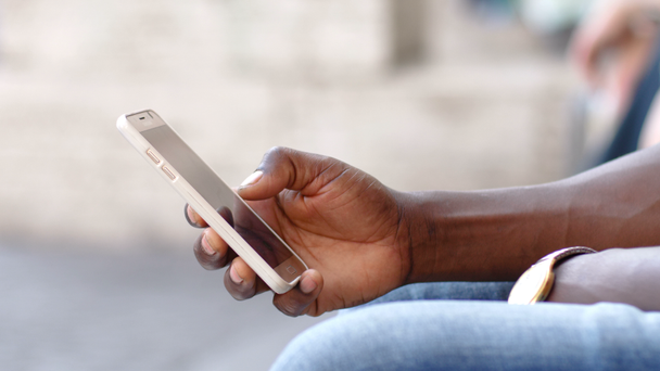 hand van de zwarte mens te typen op de smartphone - Video