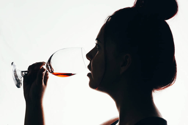 silhouette of beautiful woman drinking red wine - Fotoğraf, Görsel