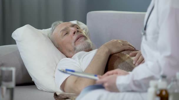 Retired man lying in bed and chatting with physician, healthcare and medicine - Felvétel, videó