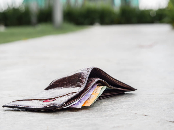 Ztracené kožená peněženka s kapkou peníze na chodníku  - Fotografie, Obrázek