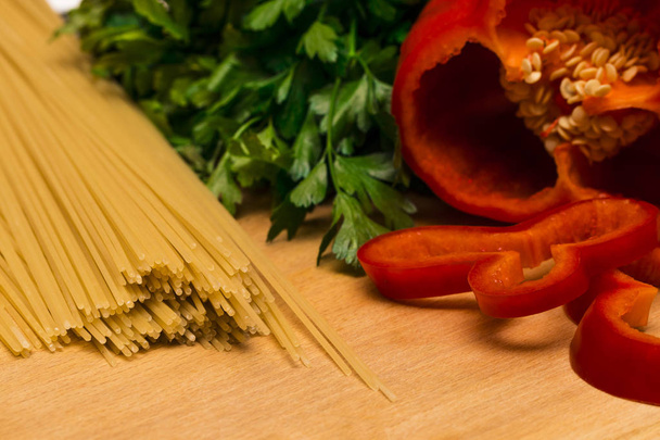 Ingredienti freschi per la cottura: pasta, peperoni e prezzemolo
 - Foto, immagini