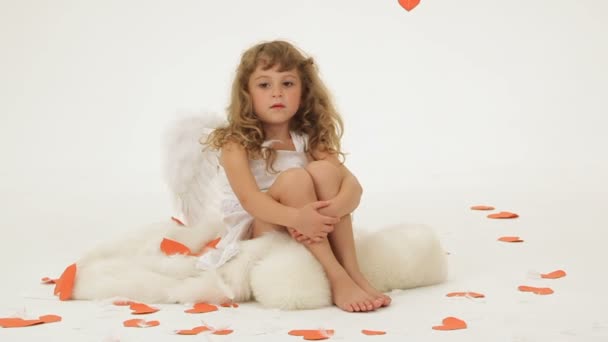 κοριτσάκι ντυμένος σαν Άγγελος περιβάλλεται με καρδιές χαρτί. - Πλάνα, βίντεο