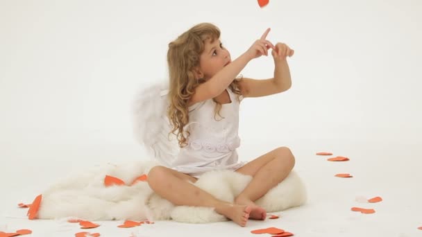 malá holčička, oblečený jako anděl obklopený papírové srdce. - Záběry, video
