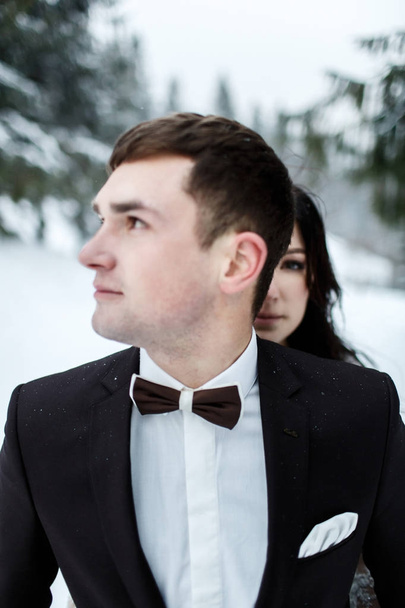  bride and groom in the winter forest - Foto, afbeelding