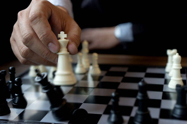 Geschäftsmann spielt Schach mit König - Schachfigur Weiß stürzt ab - Foto, Bild