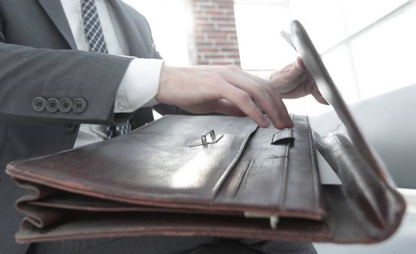 businessmans hand with suitecase in a modern office - Fotografie, Obrázek
