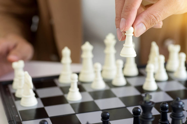 Бизнесмен думает, как играть в шахматы концепции бизнес-стратегии
 - Фото, изображение