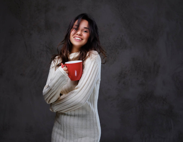Emotional woman holds red coffee cup. - Photo, Image