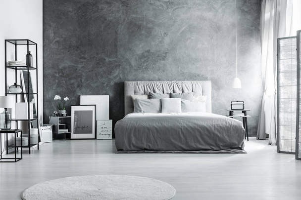 Bed against dark textured wall - Valokuva, kuva