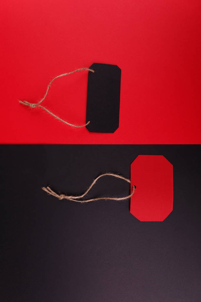 Close-up of a black tag on a red background and a red tag on a black background. - Photo, image