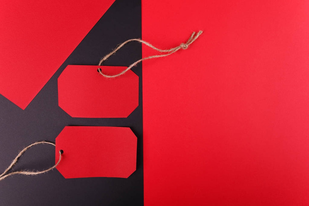 Close-up of a red bright tag is located in the left part on a black curve background - Foto, Bild