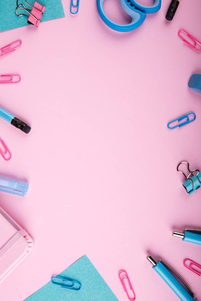 A close-up of a blue and pink office on a bright pink background. View from above. Blue and pink office. A lot of school objects. - Foto, Bild