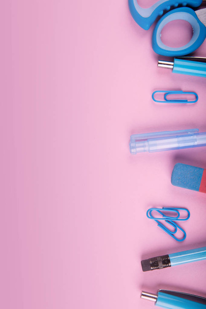 A close-up of a blue and pink office on a bright pink background. View from above. Blue and pink office. A lot of school objects. - Foto, immagini