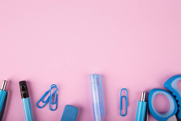 A close-up of a blue and pink office on a bright pink background. View from above. Blue and pink office. A lot of school objects. - Zdjęcie, obraz