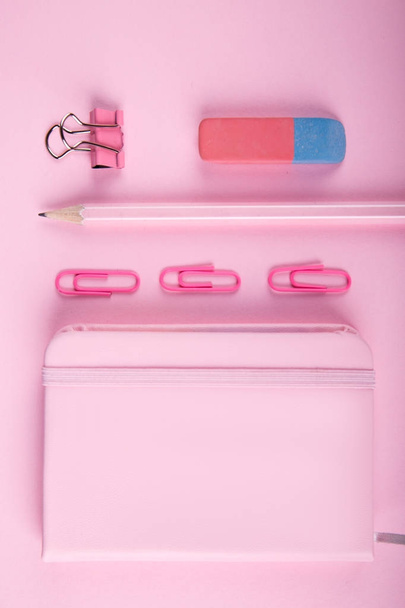 A close-up of a blue and pink office on a bright pink background. View from above. Blue and pink office. A lot of school objects. - Фото, зображення