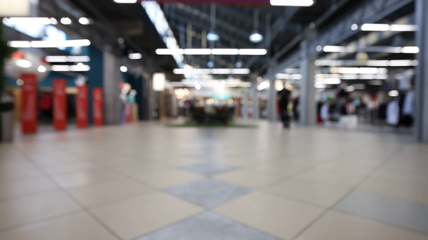 Ihmiset shoppailevat ostoskeskuksessa, hämärtyvät keskitetystä taustasta
 - Materiaali, video