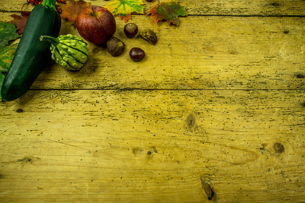 Décoration d'automne sur une planche de bois rustique avec courgettes, citrouille, feuilles d'automne
 - Photo, image