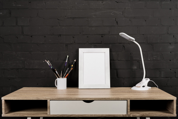 photo frame and table lamp at workplace - Foto, immagini
