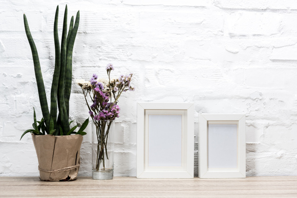 empty photo frames and flowers on table - Photo, Image