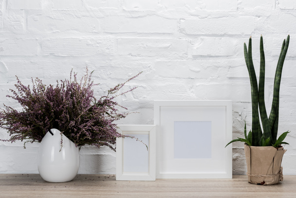 empty photo frames and flowers on tabletop - Photo, Image