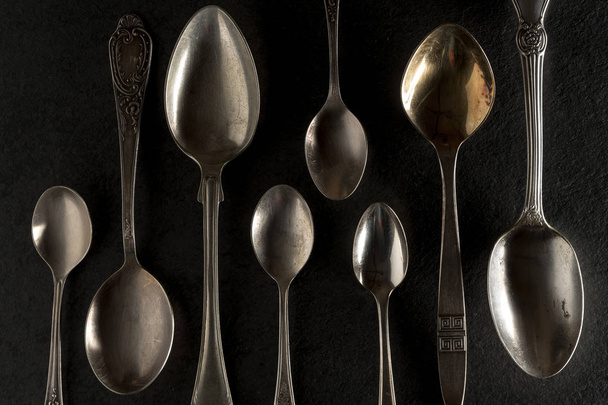 Different spoons on a black stone close-up - Foto, afbeelding